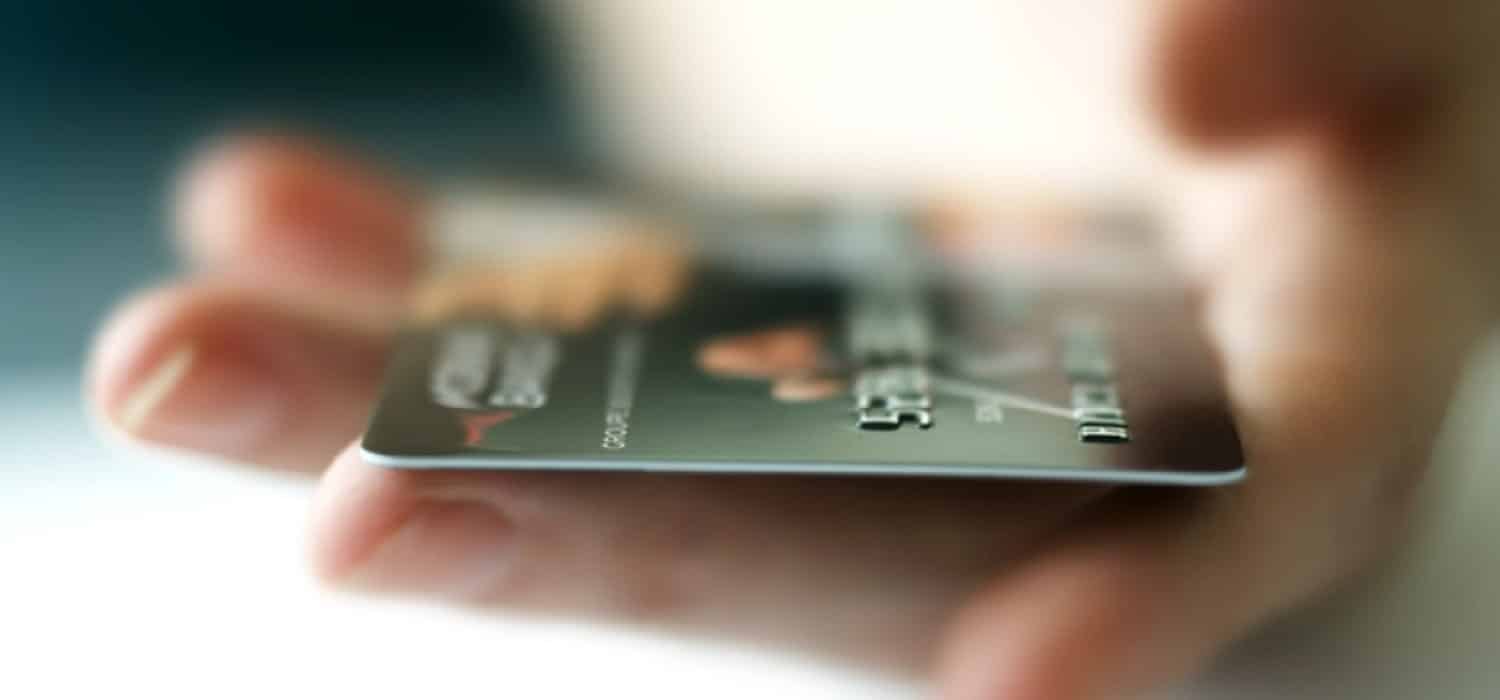 банківська кредитна карта золотистого кольору в руці людини